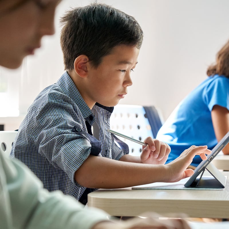Students Working From Tablets at Desks 800x800